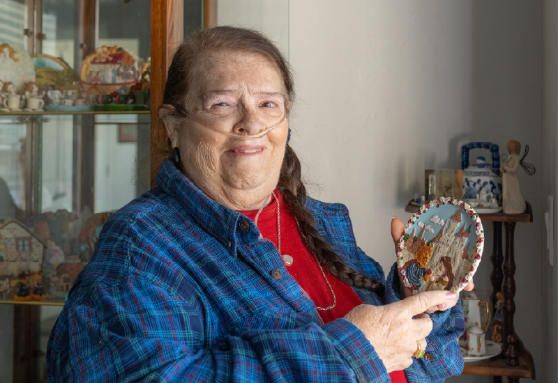 A woman holding up a craft