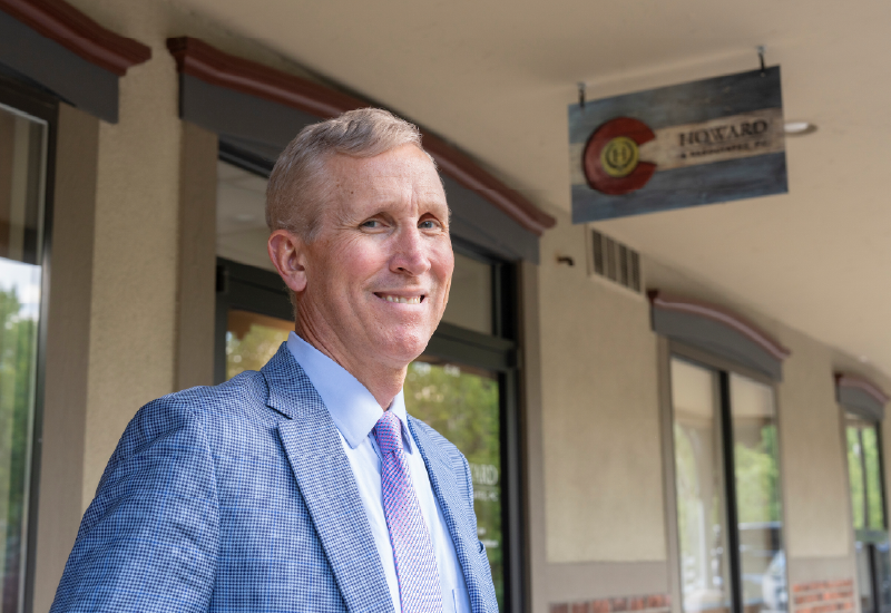 A man in a suit standing outside of a an office