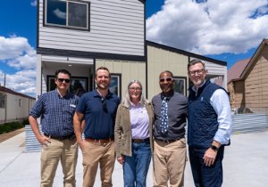 Five people standing in front of a home