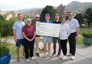 A group of people holding a large check made out to Project Project Diakonia